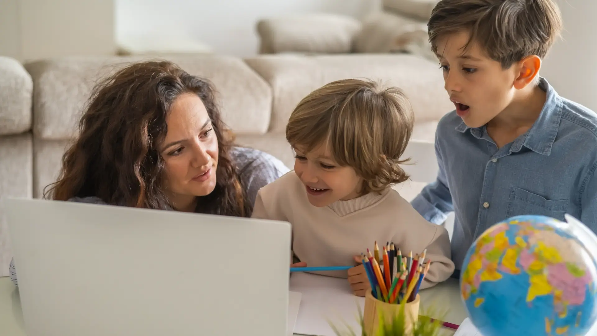 Family learning together with laptop and globe.